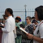 Grupo diverso de pessoas participa de uma oração ao ar livre, em Chinsurah, na Índia.