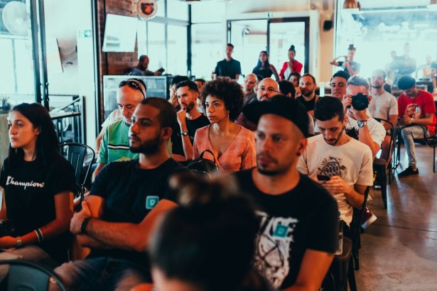 Participantes acompanham atentamente uma apresentação durante um seminário em ambiente interno.